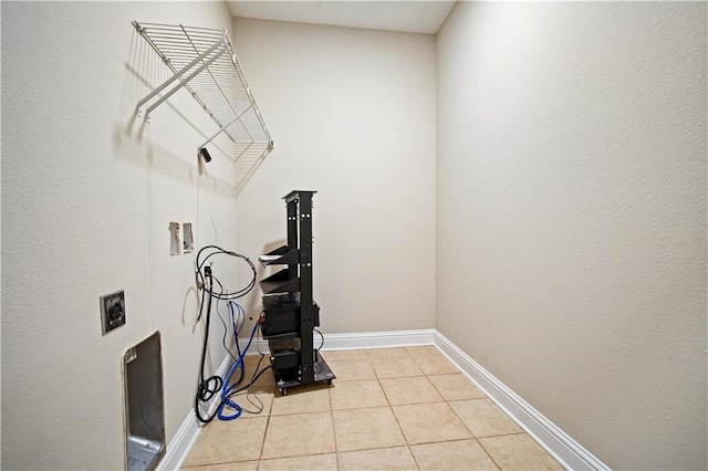 clothes washing area with hookup for a washing machine, light tile patterned floors, baseboards, and laundry area