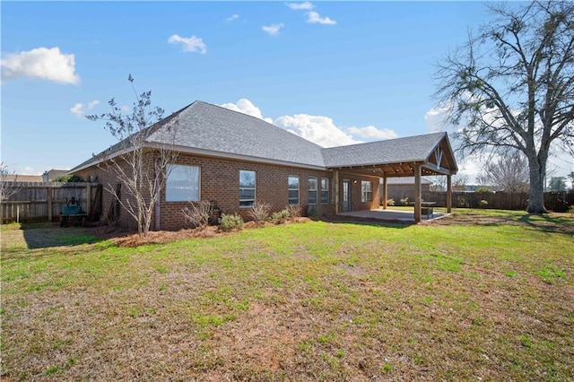 back of property featuring a patio, a lawn, brick siding, and a fenced backyard