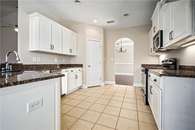 kitchen with visible vents, light tile patterned floors, appliances with stainless steel finishes, arched walkways, and white cabinets