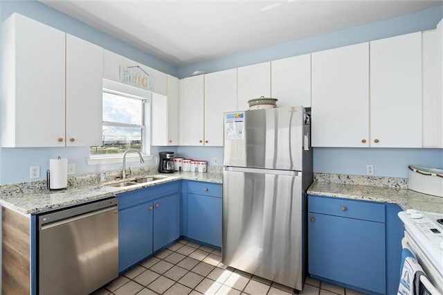 2344 Island Shores Dr, Dauphin Island, AL 36528 - kitchen featuring stainless steel appliances, a sink, blue cabinetry, white cabinetry, and light tile patterned floors