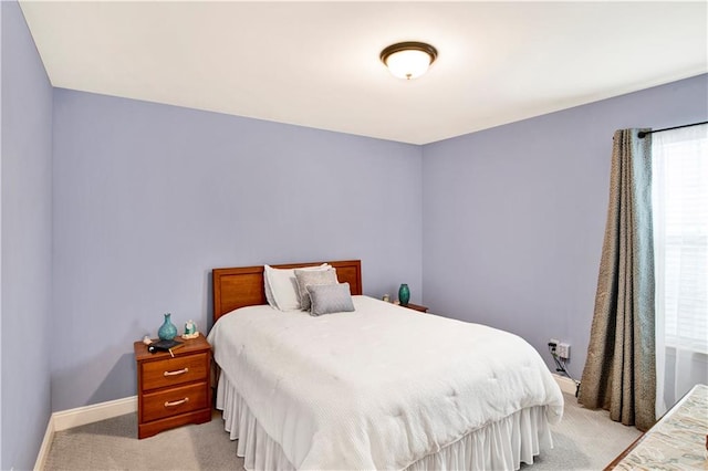 bedroom featuring light colored carpet and baseboards