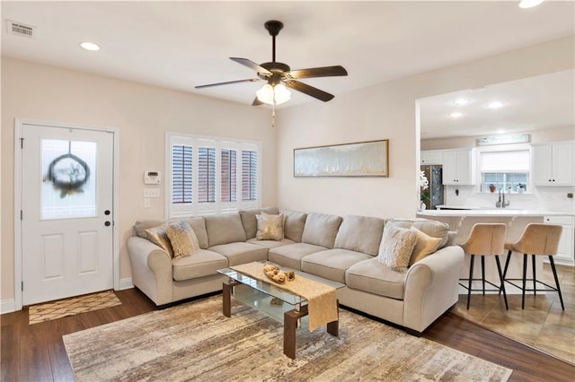 living room with sink, ceiling fan, and dark hardwood / wood-style floors