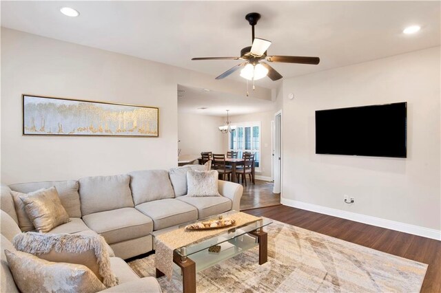 living room featuring dark wood-type flooring and ceiling fan