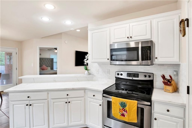 kitchen featuring stainless steel appliances, tasteful backsplash, a peninsula, and white cabinets