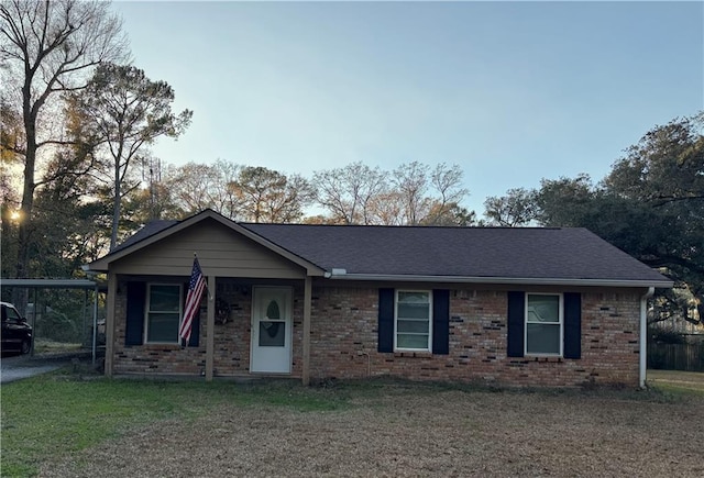 ranch-style home featuring brick siding, a front yard, and a shingled roof