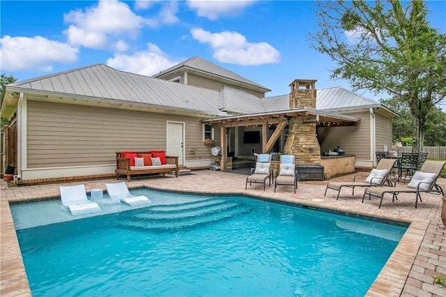 rear view of property with exterior bar and a patio area