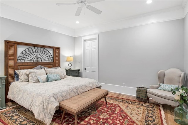 bedroom with crown molding, wood-type flooring, and ceiling fan