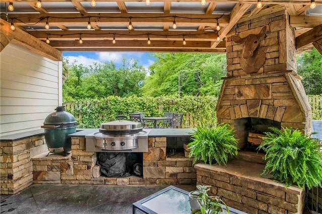 view of patio featuring area for grilling, grilling area, and an outdoor stone fireplace