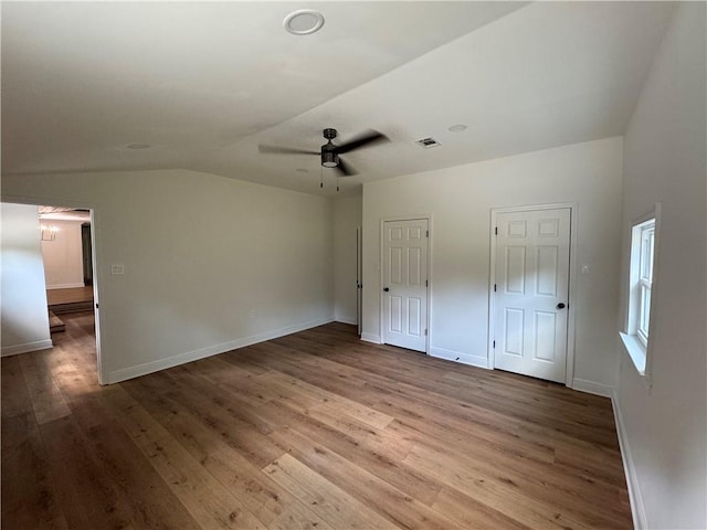 unfurnished bedroom featuring ceiling fan, vaulted ceiling, and wood-type flooring