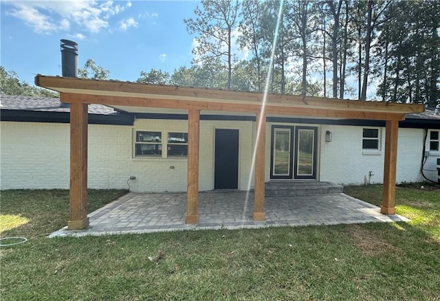 back of property featuring a patio area and a lawn