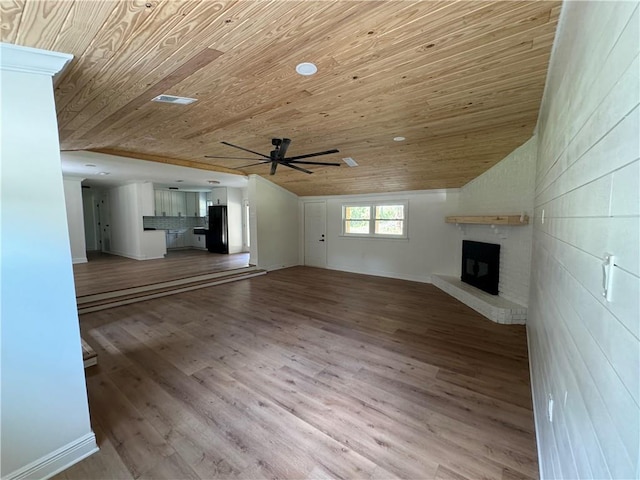 unfurnished living room featuring light wood-type flooring, a fireplace, vaulted ceiling, and wooden ceiling