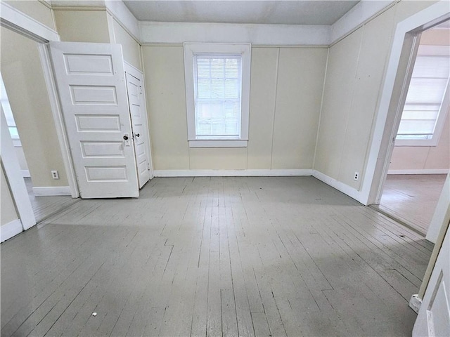 spare room featuring a wealth of natural light and light hardwood / wood-style floors