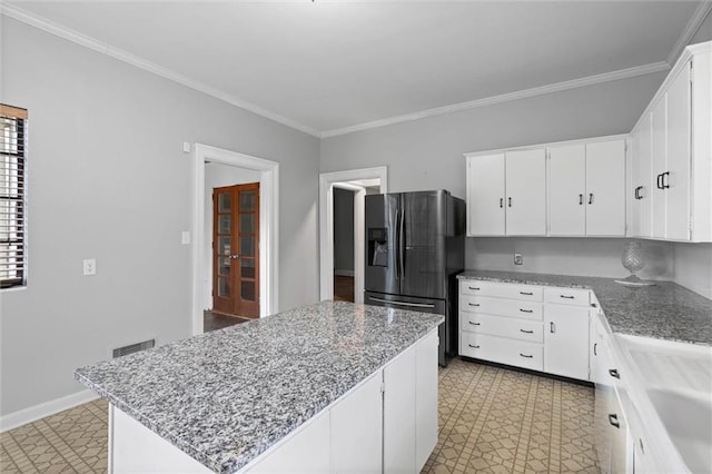 2007 Levert Dr N, Mobile, AL 36607 - kitchen with refrigerator with ice dispenser, light flooring, a kitchen island, white cabinetry, and ornamental molding