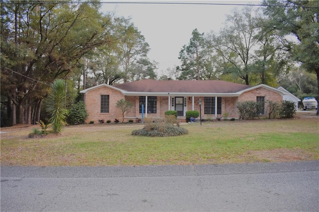 single story home with brick siding, covered porch, and a front yard