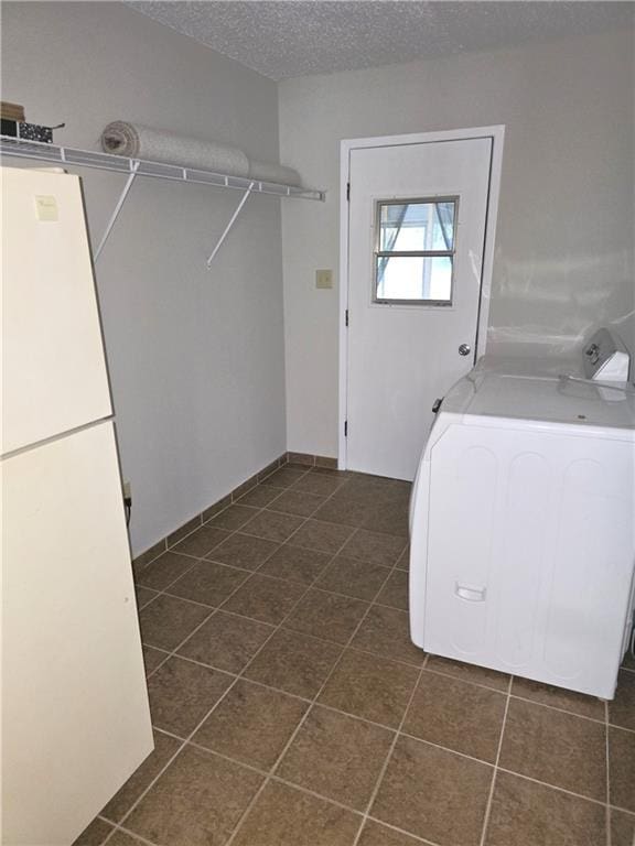 laundry room featuring laundry area, dark tile patterned floors, washer / clothes dryer, and a textured ceiling