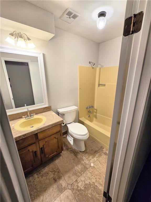 bathroom with toilet, visible vents, shower / bathing tub combination, and vanity