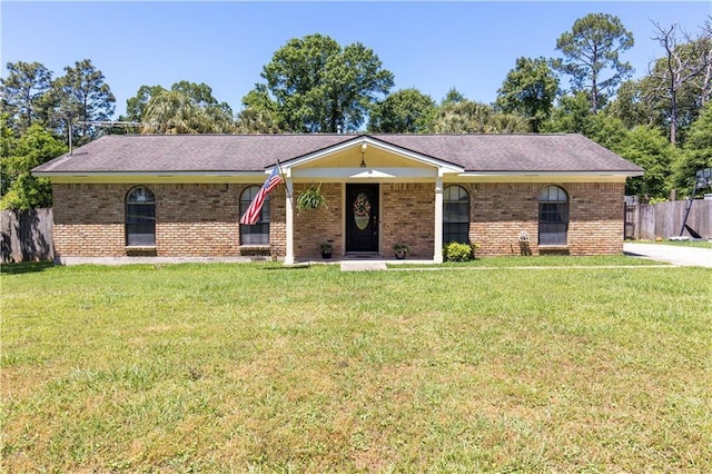 ranch-style home with fence, brick siding, and a front yard