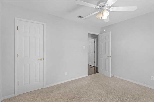 unfurnished bedroom with carpet, baseboards, a ceiling fan, and visible vents