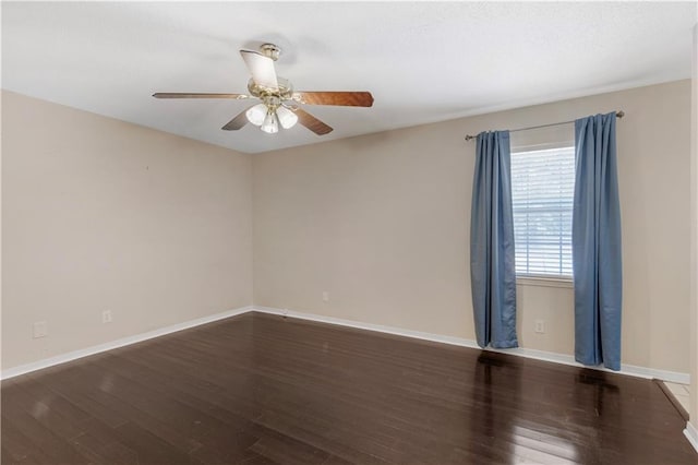 spare room with baseboards, ceiling fan, and wood finished floors