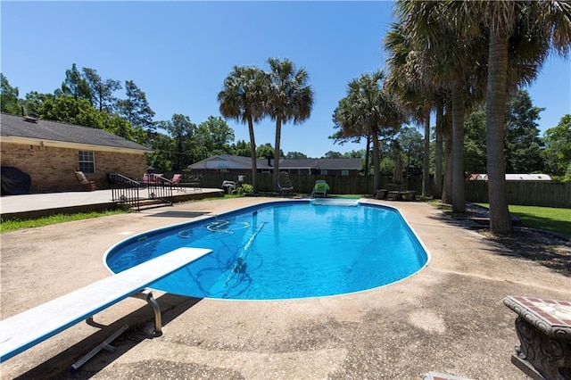 view of pool featuring a patio, a diving board, a deck, a fenced backyard, and a fenced in pool
