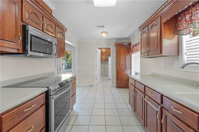 kitchen featuring light countertops, light tile patterned floors, stainless steel appliances, and visible vents