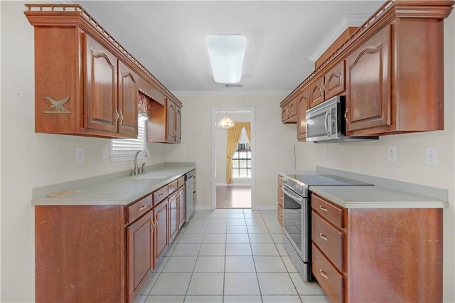 kitchen with light tile patterned floors, light countertops, appliances with stainless steel finishes, and a sink