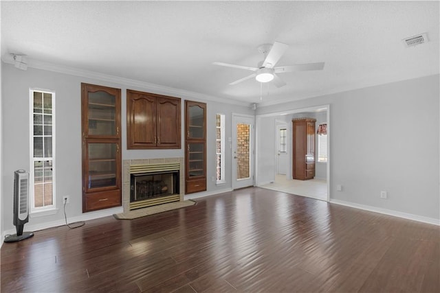 unfurnished living room with plenty of natural light, a ceiling fan, visible vents, and wood finished floors