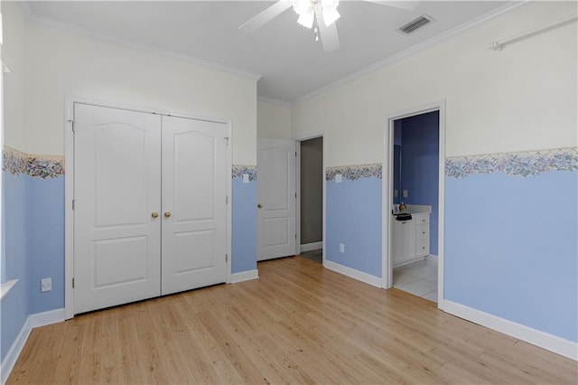 unfurnished bedroom with a closet, ornamental molding, and light hardwood / wood-style flooring