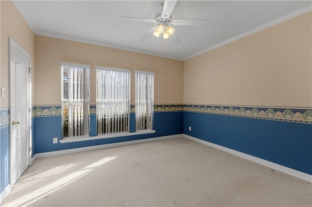 spare room with crown molding, carpet, and ceiling fan