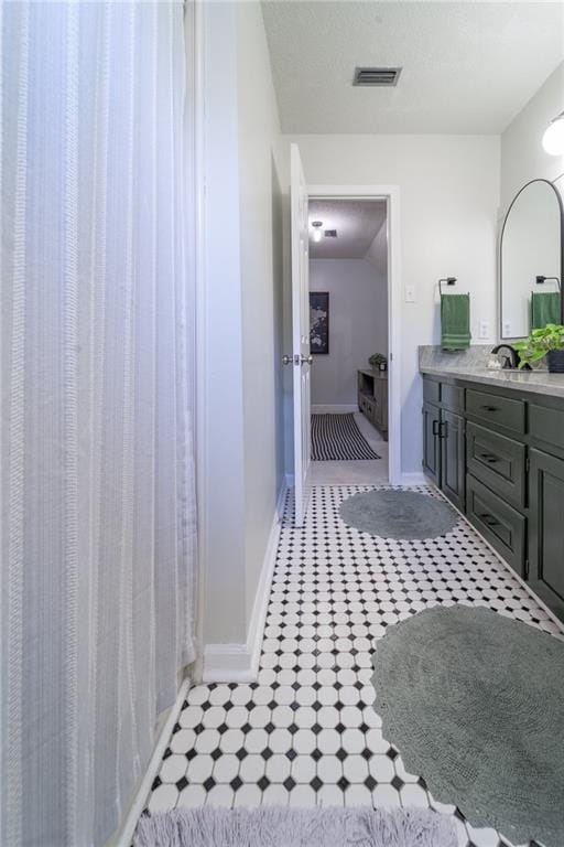 bathroom with vanity, visible vents, and baseboards