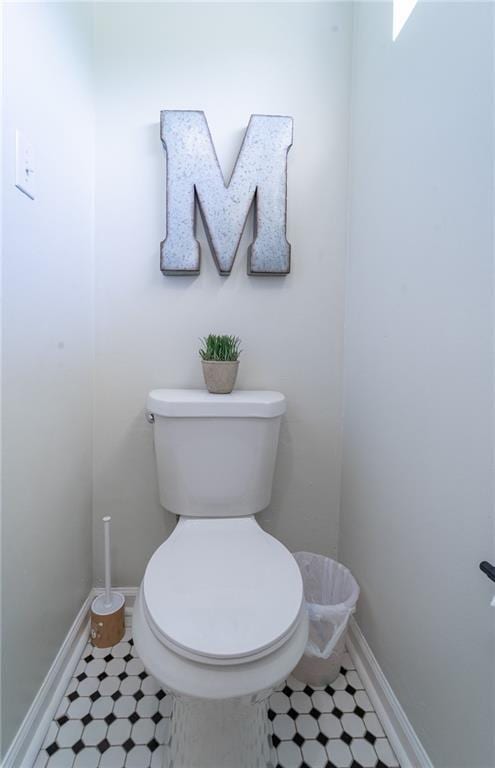 bathroom featuring tile patterned flooring, baseboards, and toilet