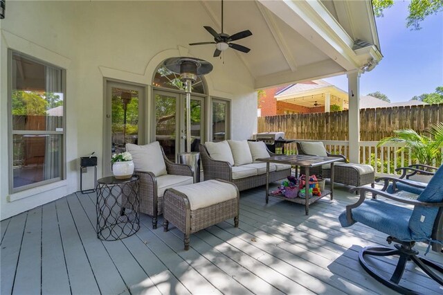 wooden terrace featuring outdoor lounge area, fence, and a ceiling fan
