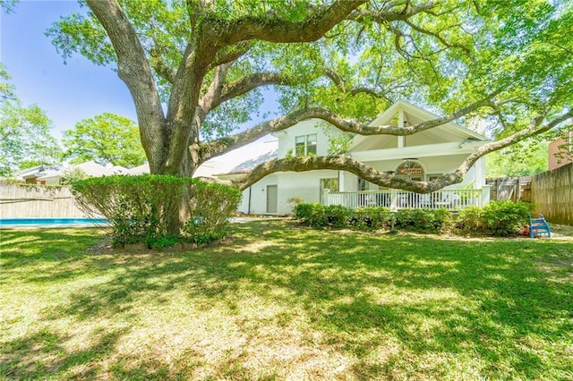 view of yard with covered porch and fence
