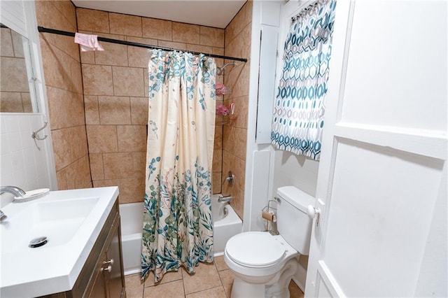 full bathroom featuring toilet, tile walls, tile patterned flooring, sink, and shower / tub combo with curtain