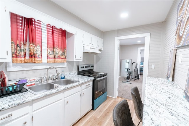 kitchen with light wood-type flooring, stainless steel electric range oven, sink, and white cabinets