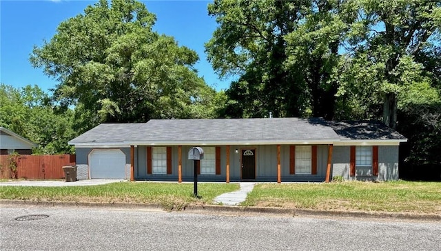 ranch-style home featuring driveway, fence, covered porch, a garage, and a front lawn
