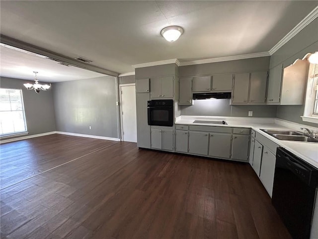 kitchen featuring dark wood-style flooring, a healthy amount of sunlight, a sink, a chandelier, and black appliances