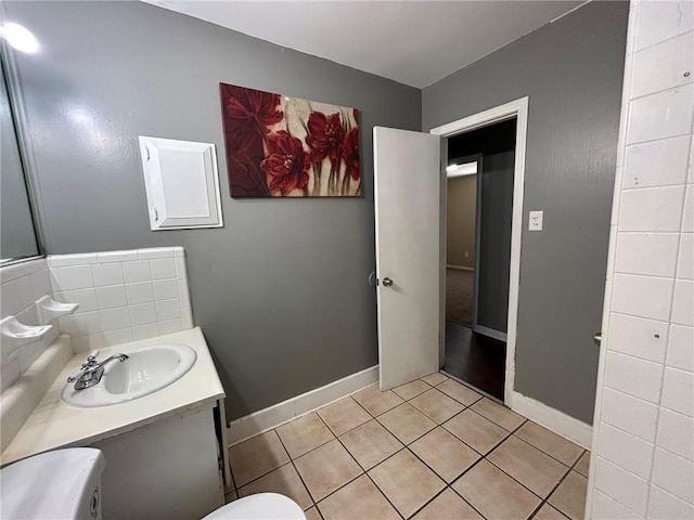 bathroom featuring baseboards, tile patterned flooring, and vanity