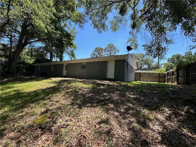 back of house featuring fence and a lawn