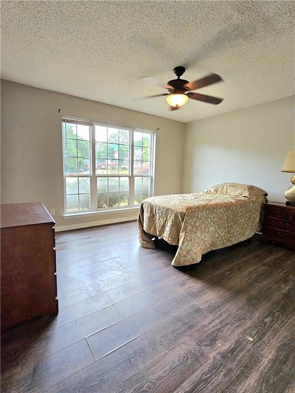 bedroom featuring ceiling fan, a textured ceiling, and dark hardwood / wood-style floors