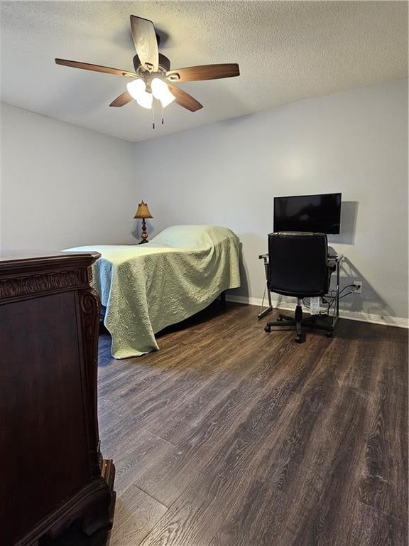 bedroom with ceiling fan, dark wood-type flooring, and a textured ceiling