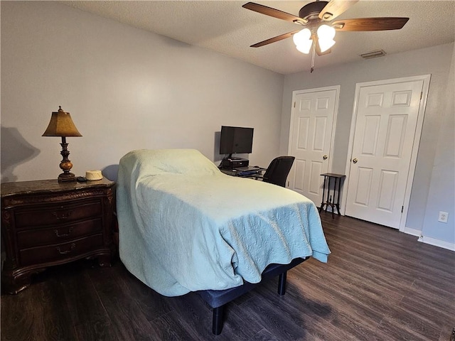 bedroom featuring a textured ceiling, ceiling fan, and dark hardwood / wood-style flooring