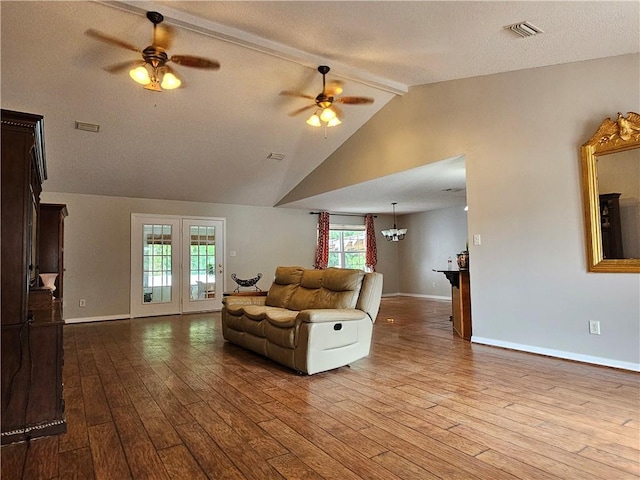 living room featuring lofted ceiling, ceiling fan, hardwood / wood-style floors, and a textured ceiling