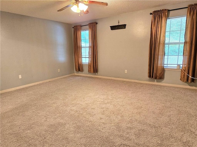 carpeted empty room with a textured ceiling and ceiling fan