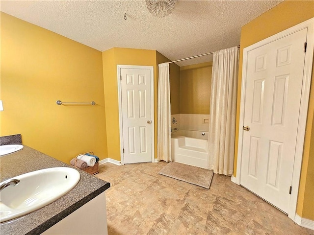 bathroom featuring vanity, a bathing tub, and a textured ceiling