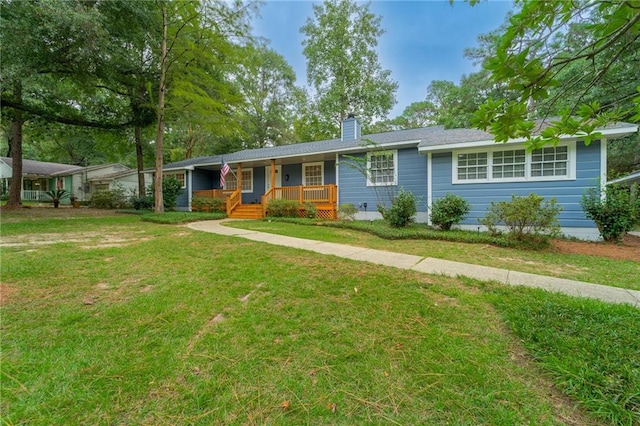 ranch-style home featuring covered porch and a front lawn