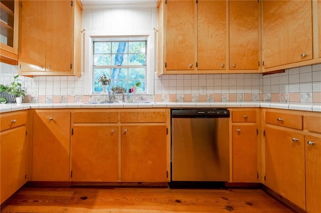 kitchen with dishwasher, light wood-type flooring, and tasteful backsplash