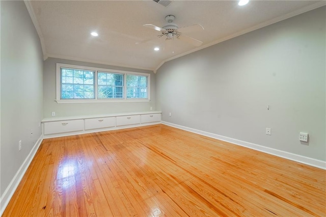 empty room featuring ceiling fan, lofted ceiling, crown molding, and light hardwood / wood-style flooring