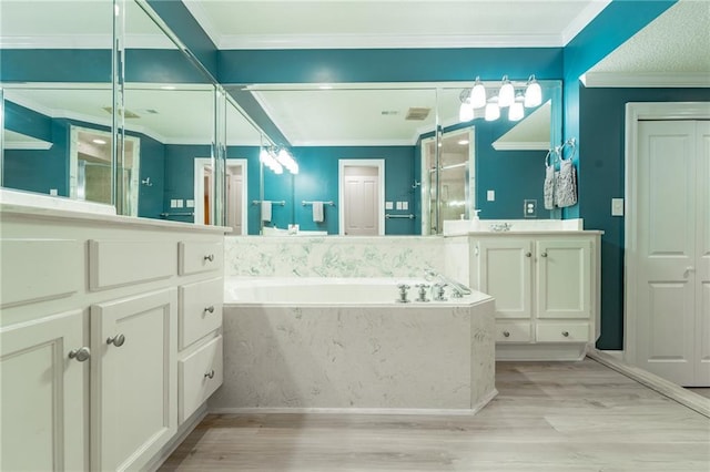 bathroom with wood-type flooring, vanity, a relaxing tiled tub, and crown molding