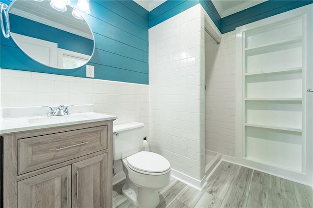 bathroom with vanity, wood-type flooring, tile walls, and ornamental molding